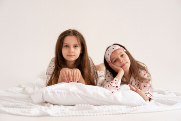 Pajama party. Happy children's laughter. Happy girls laughing, lying next to each other. Concept of...