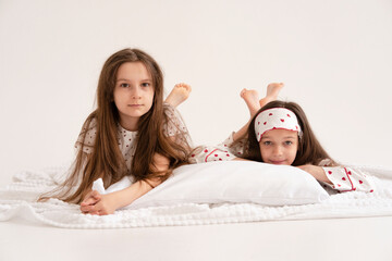 Pajama party. Happy children's laughter. Happy girls laughing, lying next to each other. Concept of...
