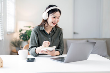 Asian business woman with headphone talking to her colleagues about plan in video conference, using...