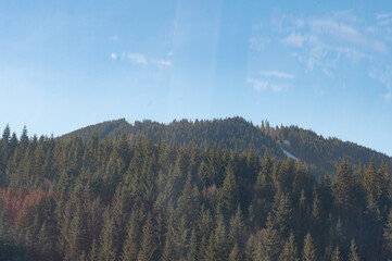 Majestic green hills rise towards a clear blue sky at midday, showcasing the beauty of nature's...