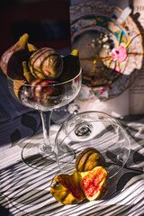 Juicy figs in a ceramic bowl on a wooden table - still life with natural light