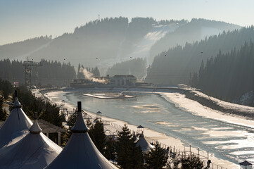 Winter wonderland landscape with snow-capped mountains and serene frozen river in the early morning...