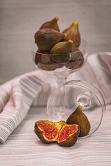 Juicy figs in a ceramic bowl on a wooden table - still life with natural light