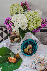 Juicy figs in a ceramic bowl on a wooden table - still life with natural light