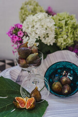 Juicy figs in a ceramic bowl on a wooden table - still life with natural light