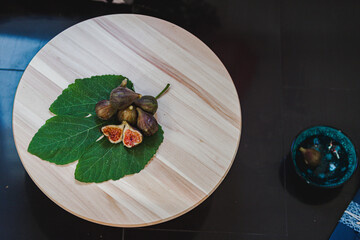 Juicy figs in a ceramic bowl on a wooden table - still life with natural light