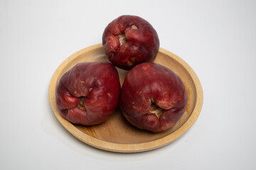 Fresh water apples are neatly arranged on a wooden plate.
