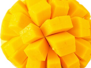 Vibrant yellow mango cubes artfully arranged on a white background