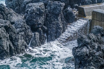 Rough Volcanic Rock Formations Along the Coastline of Sao Jorge Island, Azores, With Foaming Ocean Water Cascading into Natural Pools. Rugged cliffs, Atlantic waves, unique geology, coastal beauty