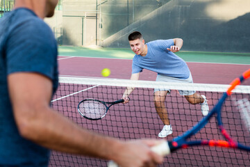 Young man training to play tennis on the tennis court outdoor