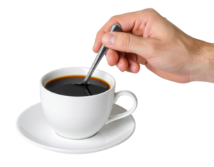 A hand stirs a white ceramic cup filled with black coffee on a matching saucer using a small metal spoon.