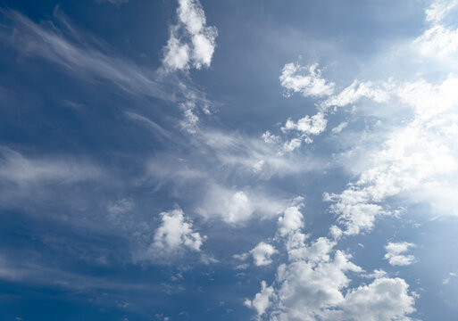 dynamic sky scene featuring wispy cirrus streaks and fluffy cumulus clouds scattered across a deep