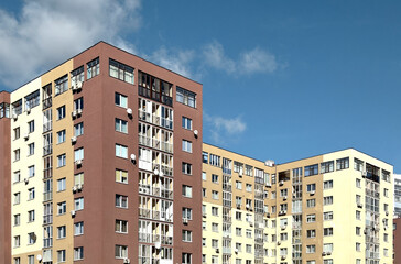 Fototapeta premium Modern apartment building with a beige facade. Residential multi story block featuring balconies,