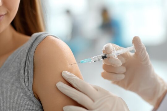Woman getting a shot in his arm - Powered by Adobe
