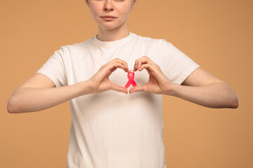 Woman Holding Pink Ribbon Symbolizing Breast Cancer Awareness