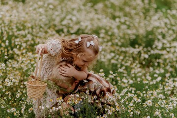A boy with hearing aids and his little sister gather daisies in a sunlit field, sharing a joyful moment of sibling bonding and inclusive childhood wonder in nature