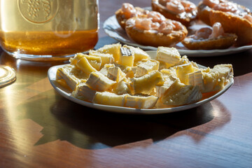 Close-up of sliced soft cheese with white rind on a plate, served on a wooden table in natural...