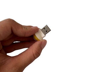 A hand holds a cute, white and yellow sheep-headed USB flash drive against a clean white background