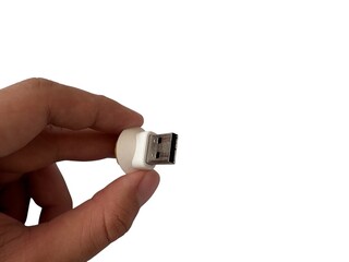 A hand holds a cute, white and yellow sheep-headed USB flash drive against a clean white background