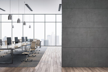 Modern open office interior with empty desks, computer monitors, and city view through large...