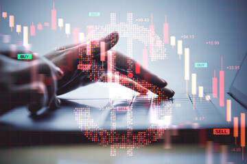 Business hand typing on laptop with red downward financial chart and Bitcoin hologram indicating...