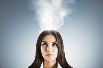 Businesswoman under pressure with steam coming out of head showing stress and burnout on blue...