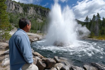 Geyser erupts near man surrounded by nature in Yellowstone National Park during a sunny day