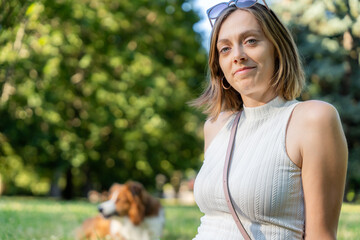 Young woman in white top relaxing in park with trees in background during sunny summer afternoon