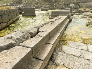 Ancient stone structures near water with moss and vegetation in a historical landscape