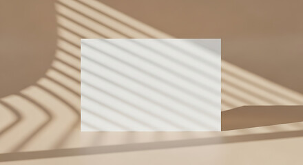 Minimalist blank white card displays sunlit window shadows on soft tan wall creating subtle texture