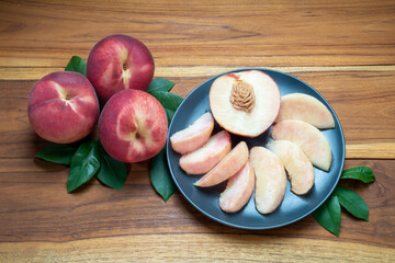 Hakuho pink Peach on black plate, Peach premium fruit on wooden background.