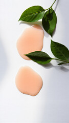 Minimalist Composition Featuring Two Blush-colored Eggs and Green Leaves on White Background