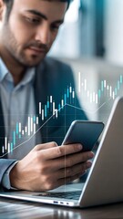 Businessman analyzing stock market data on his phone and laptop.  A graph shows upward trend.