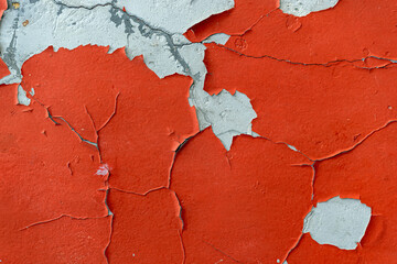 Red peeling paint texture background on wall. Red cracked paint peeling from wall, texture with...