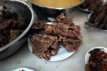 Crispy fried beef lungs (paru goreng) on a plate, part of a traditional Indonesian meal spread, ready to be enjoyed. Usually served at Rumah Makan Padang