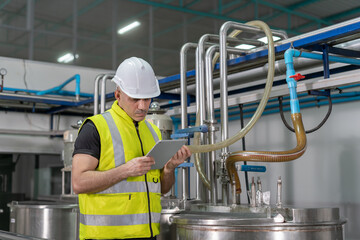 Portrait Engineers or utility staff wearing safety helmet fix the machines in the production line....