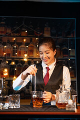 Professional female bartender preparing alcoholic drinks in a bar
