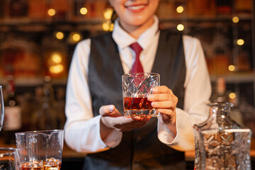 Professional female bartender preparing alcoholic drinks in a bar