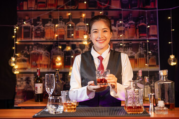 Professional female bartender preparing alcoholic drinks in a bar