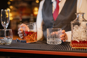 Professional female bartender preparing alcoholic drinks in a bar
