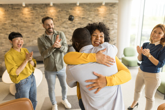 Cheerful team celebrating with a hug in an office setting