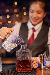 Professional female bartender preparing alcoholic drinks in a bar