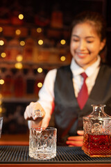 Professional female bartender preparing alcoholic drinks in a bar