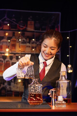 Professional female bartender preparing alcoholic drinks in a bar