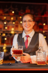 Professional female bartender preparing alcoholic drinks in a bar