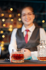 Professional female bartender preparing alcoholic drinks in a bar