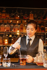  Professional female bartender preparing alcoholic drinks in a bar