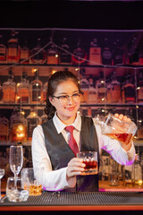 Professional female bartender preparing alcoholic drinks in a bar