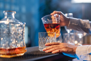 Professional female bartender preparing alcoholic drinks in a bar