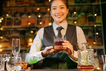 Professional female bartender preparing alcoholic drinks in a bar